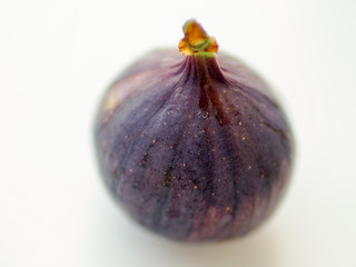 Ripe sweet fig on white blurred table. Selective focus