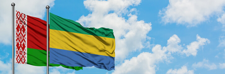 Belarus and Gabon flag waving in the wind against white cloudy blue sky together. Diplomacy concept, international relations.