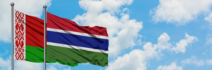 Belarus and Gambia flag waving in the wind against white cloudy blue sky together. Diplomacy concept, international relations.