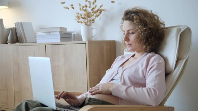 Young Pregnant Woman Using Laptop Computer At Home.