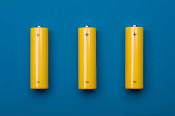 Yellow AA alkaline batteries on blue background