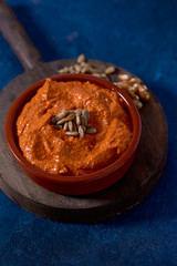 homemade muhammara in a brown earthenware bowl.