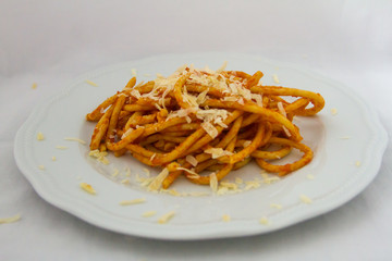 plate of bucatini amatriciana with a drop of pecorino cheese