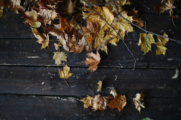 Background background with old wooden table and yellow autumnal leaves