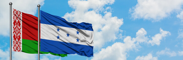Belarus and Honduras flag waving in the wind against white cloudy blue sky together. Diplomacy concept, international relations.