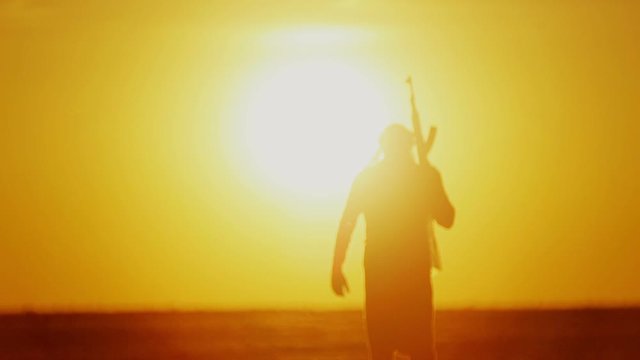 warrior with Kalashnikov at sunset day. fighter is training with a machine gun at sunset.