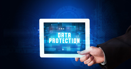 Young business person working on tablet and shows the digital sign: DATA PROTECTION
