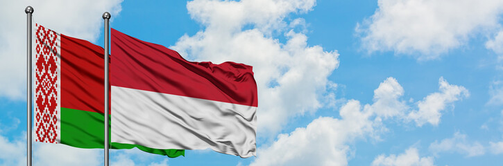 Belarus and Indonesia flag waving in the wind against white cloudy blue sky together. Diplomacy concept, international relations.