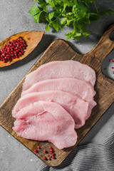 Raw Turkey meat on a wooden Board on a gray table. Top view 