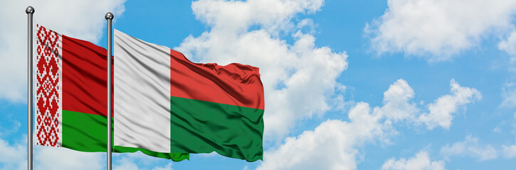 Belarus and Madagascar flag waving in the wind against white cloudy blue sky together. Diplomacy concept, international relations.