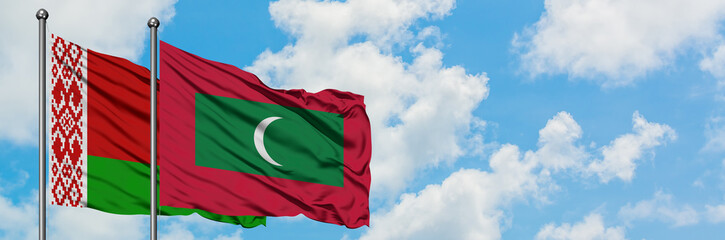 Belarus and Maldives flag waving in the wind against white cloudy blue sky together. Diplomacy concept, international relations.