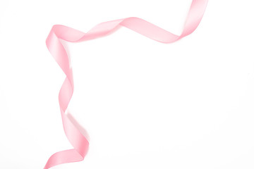 Curled pink ribbon with highlights isolated on white background, top view