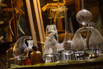Set of alchemy bottles in laboratory of alchemist. Herb in old pots with dust on  the glass surface.Alchemy symbol and objects. Poison and elixir in glass jar. Set of vessel, ampulla, flask,drink.....