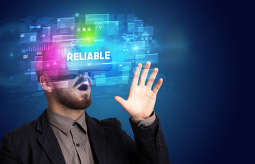 Businessman looking through Virtual Reality glasses with RELIABLE inscription, innovative security concept