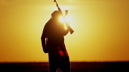 warrior with Kalashnikov at sunset day. fighter is training with a machine gun at sunset.