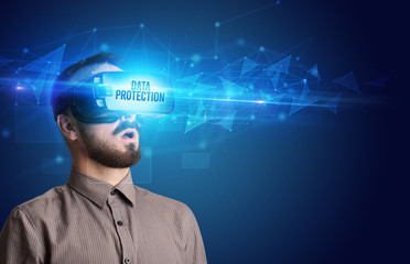 Businessman looking through Virtual Reality glasses with DATA PROTECTION inscription, cyber security concept