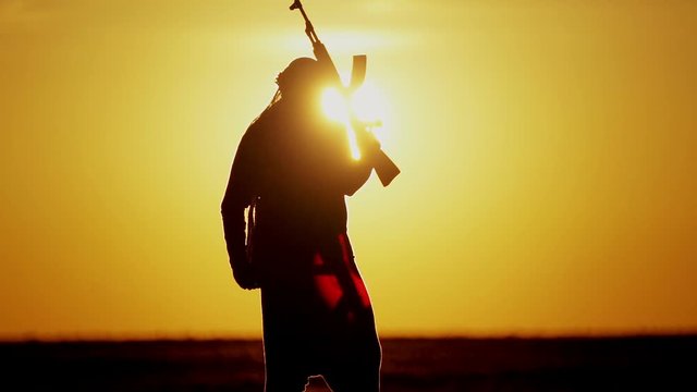warrior with Kalashnikov at sunset day. fighter is training with a machine gun at sunset.