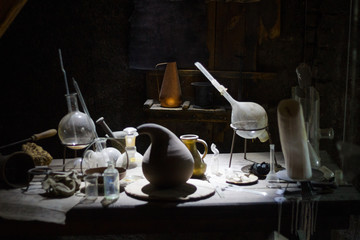 Set of alchemy bottles in laboratory of alchemist. Herb in old pots with dust on  the glass...
