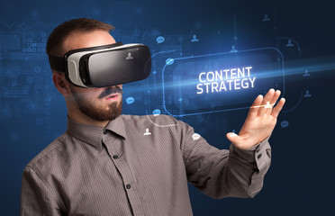 Businessman looking through Virtual Reality glasses with CONTENT STRATEGY inscription, social networking concept