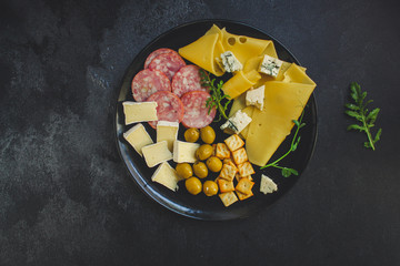 cheese board (different types of cheese plate appetizers , sausage, ham, olives, greens and more) menu concept. food background. copy space. Top view