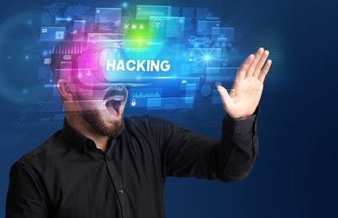 Businessman looking through Virtual Reality glasses with HACKING inscription, innovative security concept