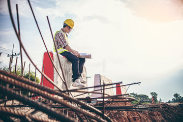 Portrait road Engineer sit down Checking Plans on Barriers To A New Highway