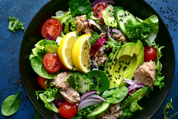 Vegetable salad with tuna and avocado. Top view with copy space.