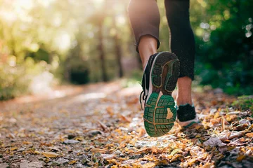 Foto op Aluminium Closeup of running shoe of the person running in the nature with beautiful sunlight. © eshana_blue