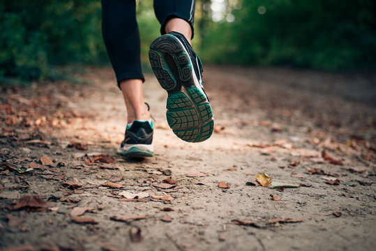 Autumn run in the nature on a trail with dry yellow leaves.