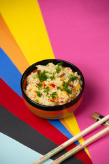 egg fried rice with bell peppers and dill on colorful backgroun