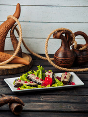 fried aubergine halves topped with chicken and walnut mix garnished with pomegranate