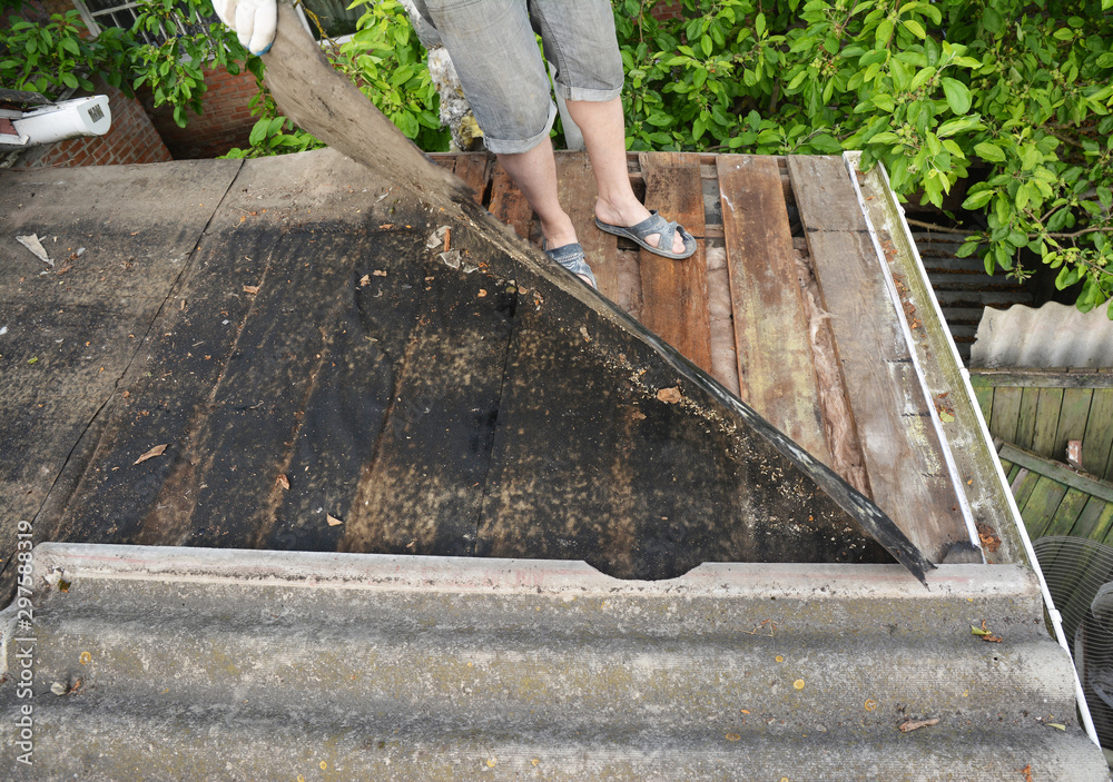 Sticker Roofer repair and renovation old asbestos roof. Old house roof with bad wet wooden beams. Roofing construction