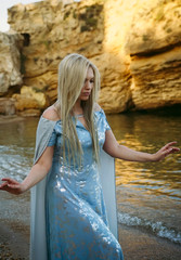 beautiful girl stands in the water on the seashore