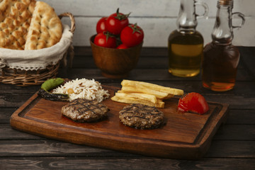grilled beef patties served with rice, fries, grilled tomato and pepper