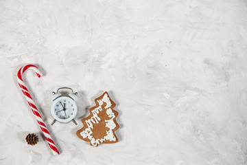 Christmas holiday background with alarm-clock, Candy canes plastering background. Close-up, top view.