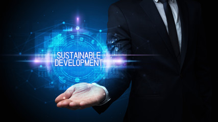 Man hand holding SUSTAINABLE DEVELOPMENT inscription, technology concept