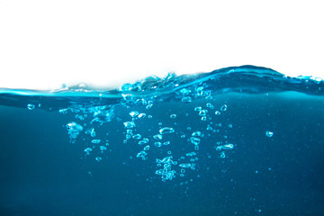 close-up shot of blue water surface and shining blue bubbles underwater with white background