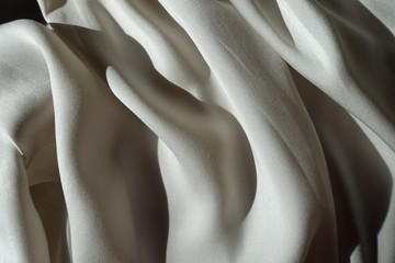 Folded thin shiny light grey chiffon fabric