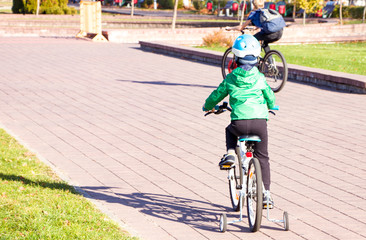 Little cyclist on a walk. The kid masters the bicycle. Serious intentions in cycling. Learning to ride a bike. The pursuit of sports.