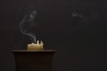 Smoke from a wax candle on a dark background. Concept of divination, magic, ritual. Copy space.