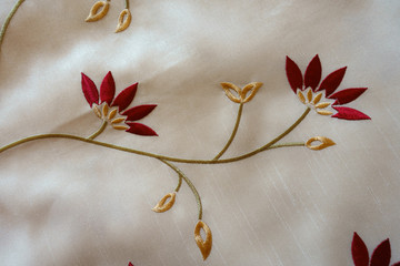 Floral embroidery on ivory white cloth from above