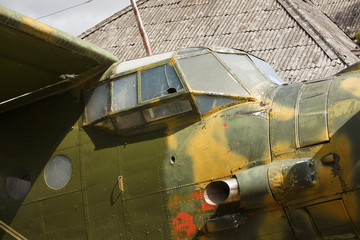 Obraz premium Cockpit and fuselage details of old plane. Old camouflage surface on a military aircraft