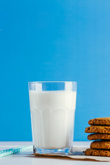 Fresh milk and tasty cookies on a blue background