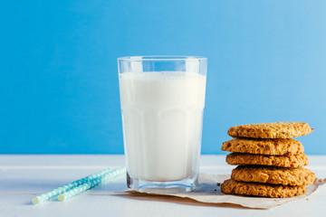 Fresh milk and tasty cookies on a blue background