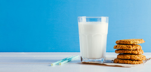 Fresh milk and tasty cookies on a blue background