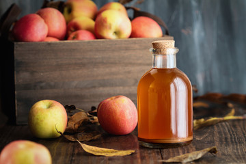 Apple cider vinegar with the mother, yeast and healthy bacteria, surrounded by fresh apples. Apple cider vinegar has long been used in naturopathy to treat things such as diabetes and high cholesterol
