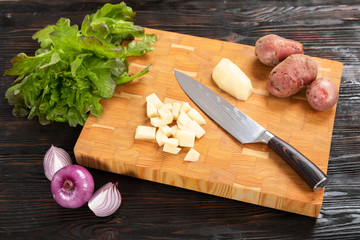 vegetables and knife on a wooden cutting board