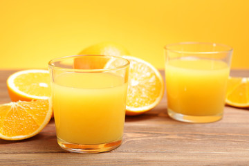 Orange juice in a glass, oranges and orange slices on the table.