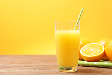 Orange juice in a glass, oranges and orange slices on the table.