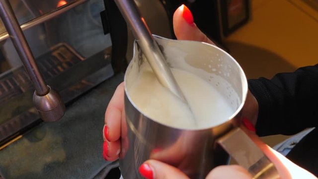Coffee machine working barist heat and shake a milk for cappuccino
